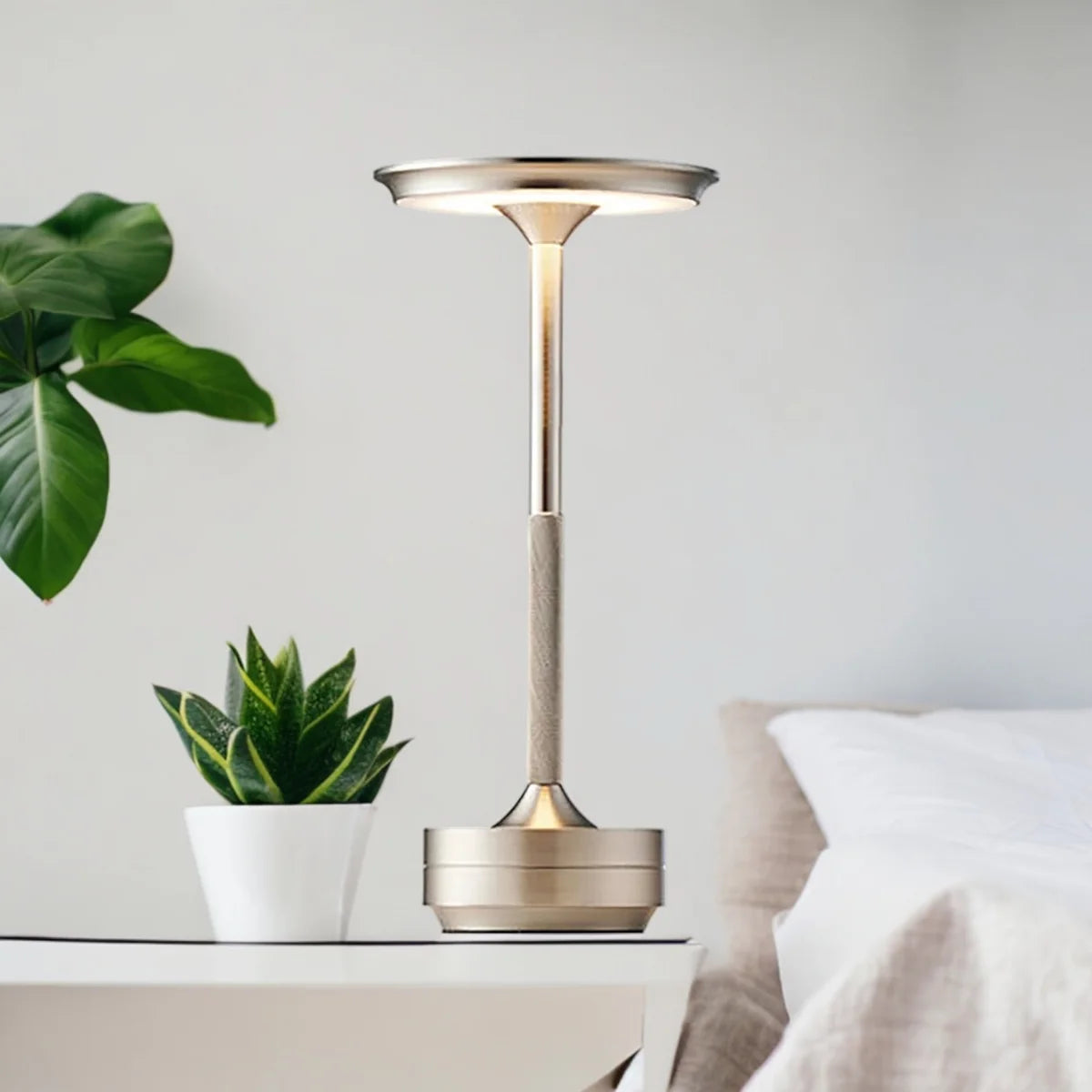 Silver Aura-lampe lyser på et hvitt nattbord