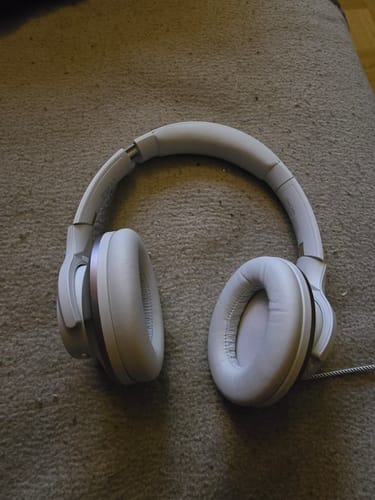 Zilverkleurige Oneodio-koptelefoon op een tapijt.